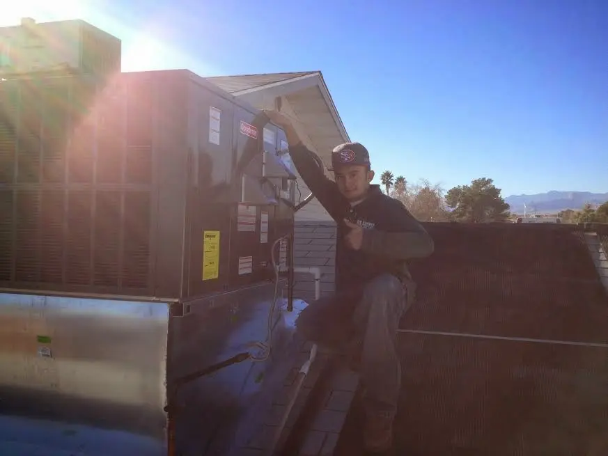 HVAC technician performing HVAC Inspection on a rooftop unit in Manchester